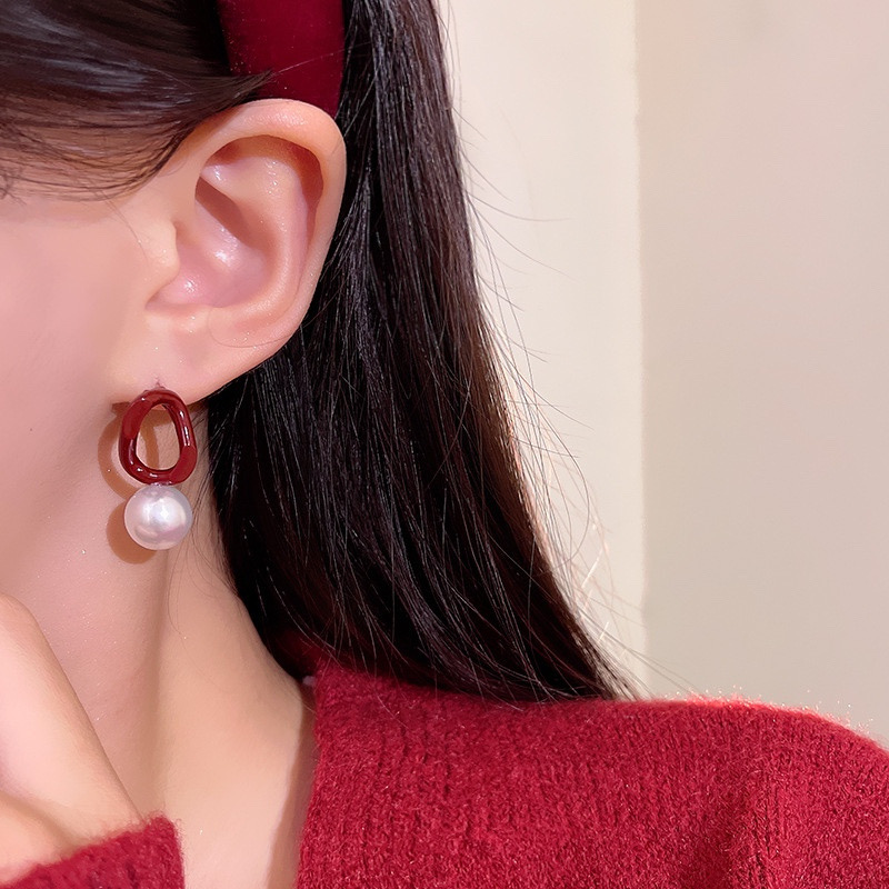 Burgundy faux pearl earrings on model