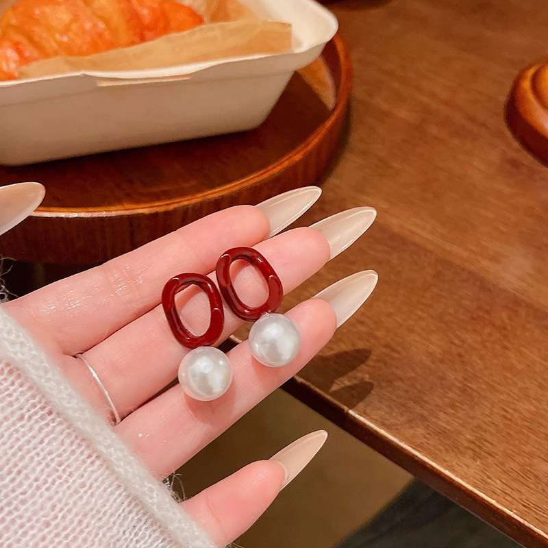 Burgundy pearl earrings hand held close up