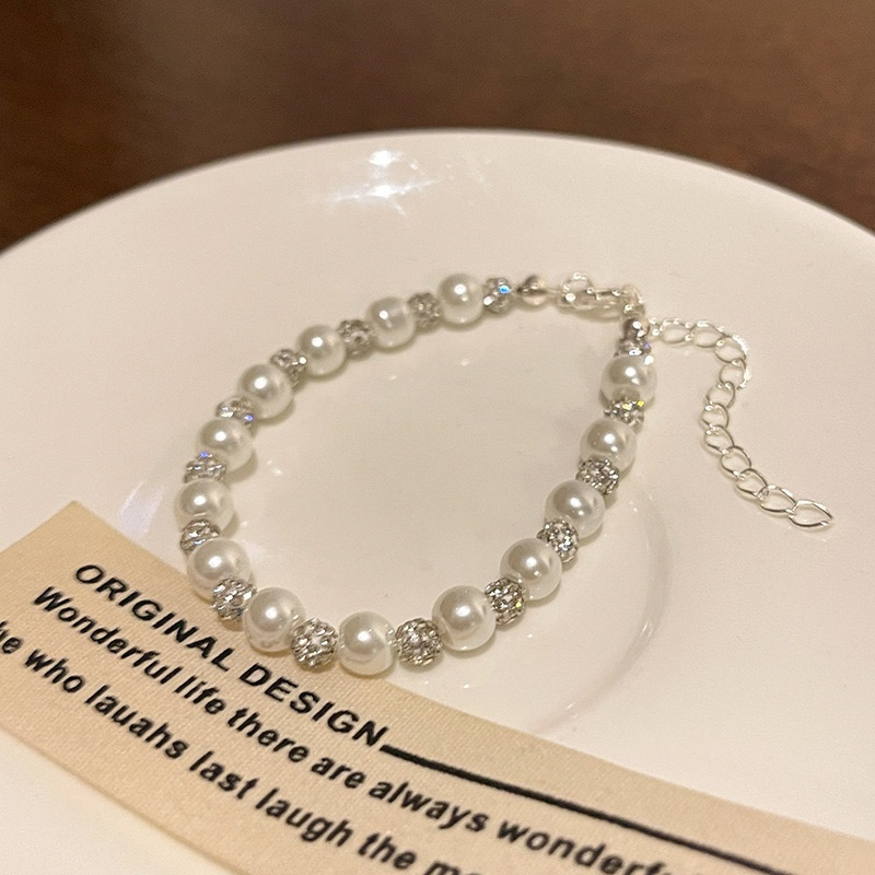  White Pearl and Sparkle Bracelet Displayed on Ceramic Plate