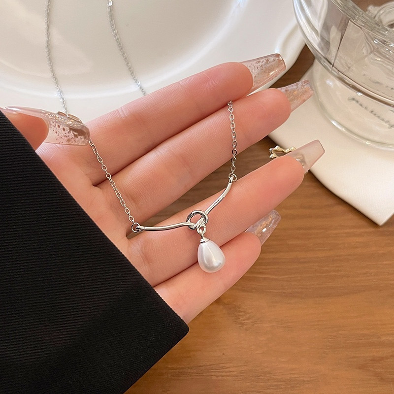 Close Up of Silver Curved Bar Necklace with Teardrop Faux Pearl Pendant