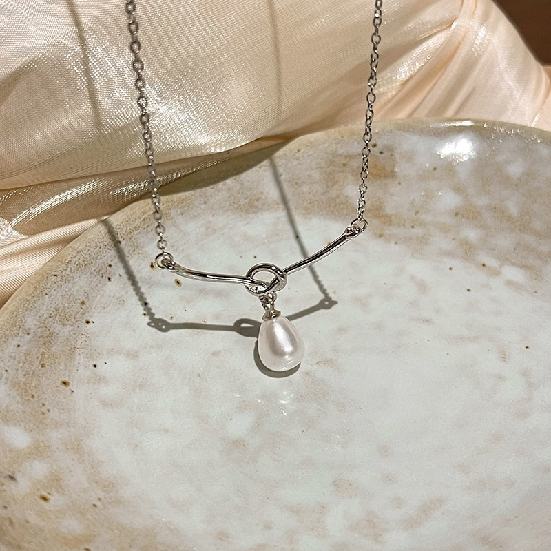 Silver Faux Pearl Drop Necklace Displayed on Light Stone Plate
