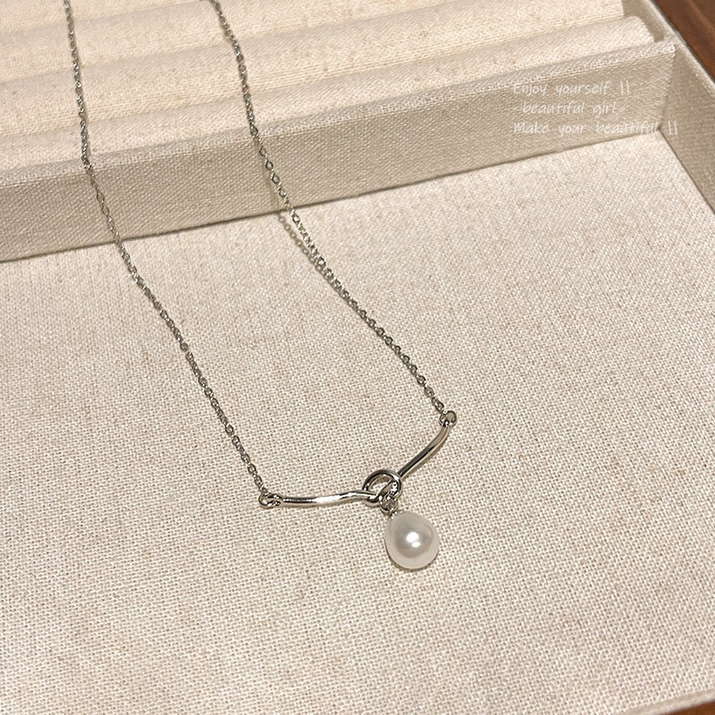 Silver Teardrop Faux Pearl Pendant Necklace Displayed on Beige Fabric Stand