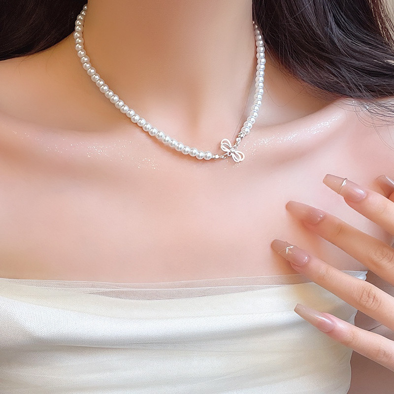 White Faux Pearl Bow Choker Necklace Worn by Model with White Off Shoulder Top