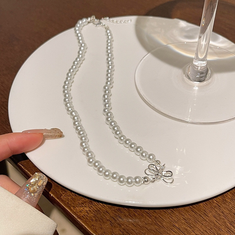 White Faux Pearl Bow Choker Necklace Displayed on White Plate