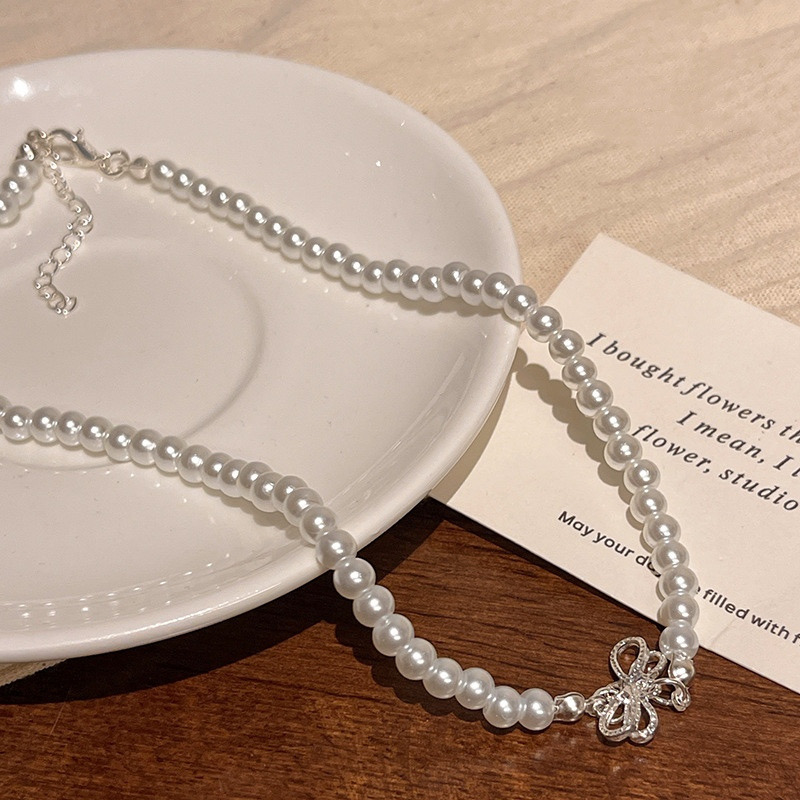 White Faux Pearl Bow Choker Necklace with Adjustable Extension Chain on White Plate