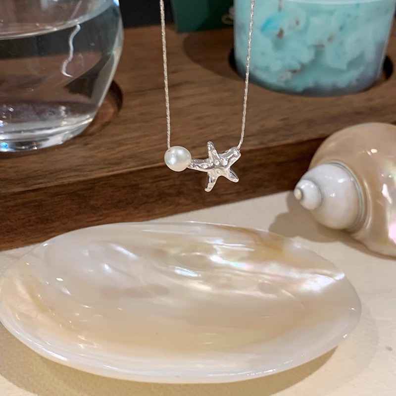 Close Up of Silver Starfish Charm and White Faux Pearl on Fine Necklace Chain