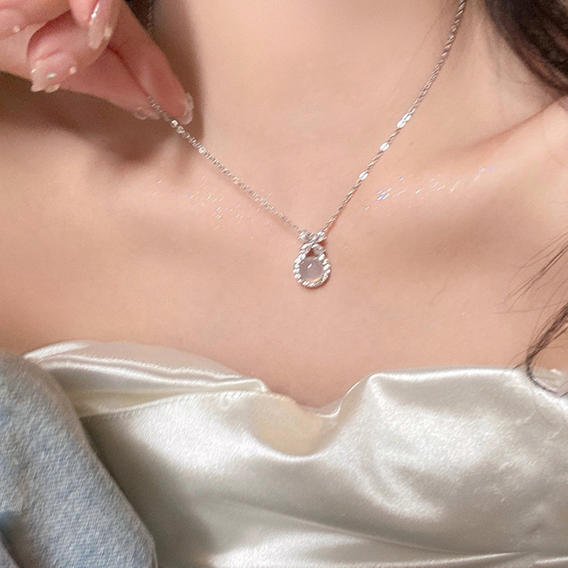 Close-Up of Woman Wearing Silver Floral Pendant Necklace with White Centerpiece
