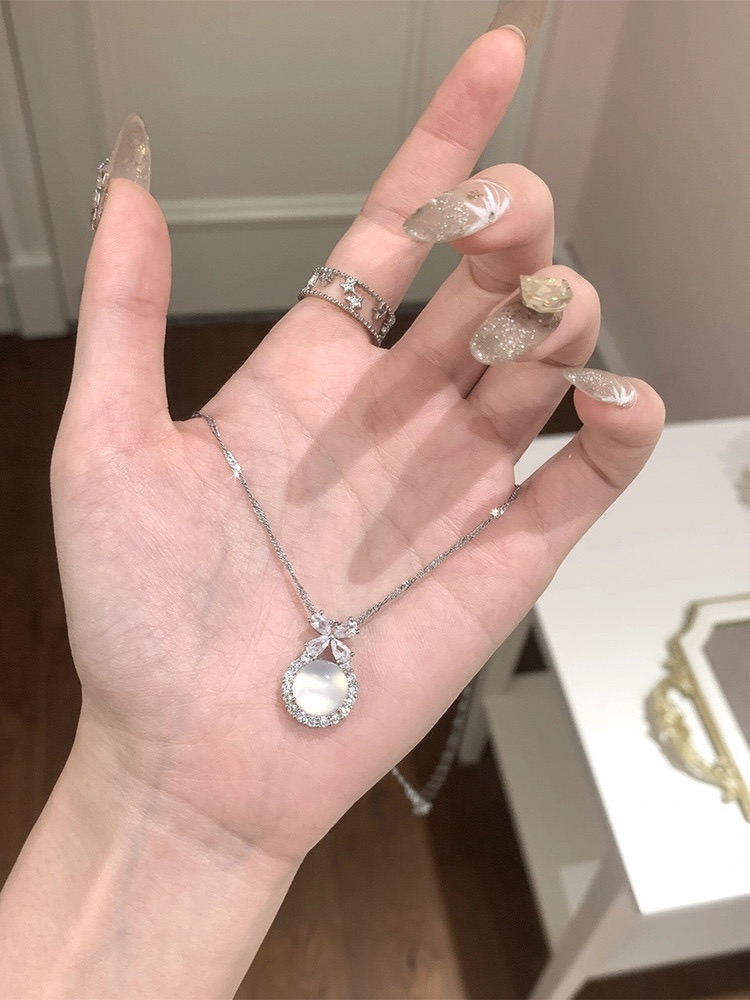 Silver Floral White Stone Pendant Necklace Displayed on Open Palm