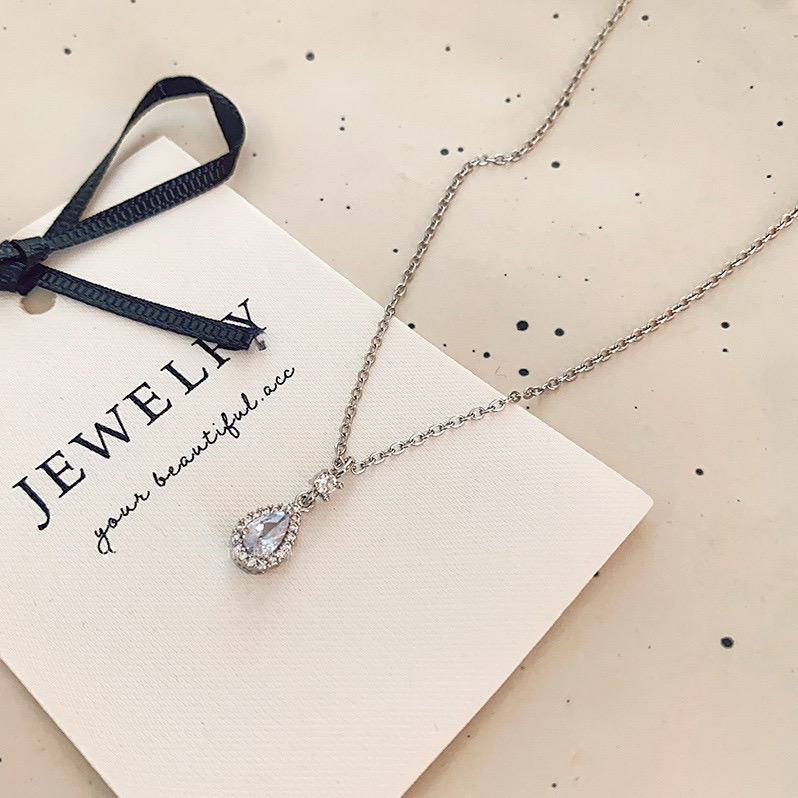 Silver zircon teardrop pendant necklace displayed on a jewelry card with sparkling stone details
