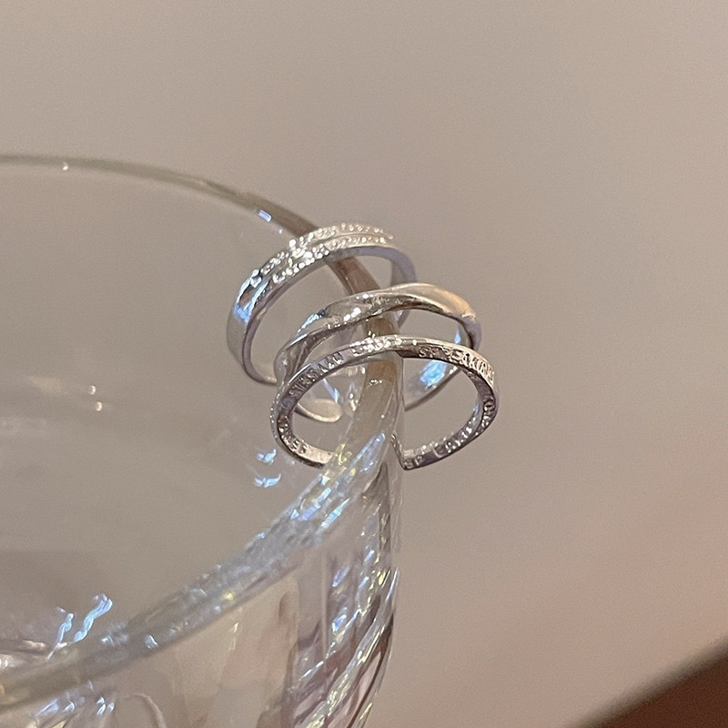 Three Silver Open Rings Displayed on Glass