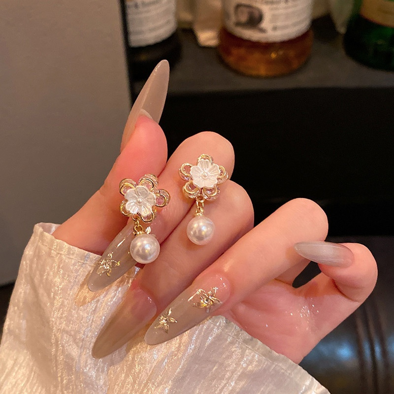 Romantic gold floral pearl earrings close-up
