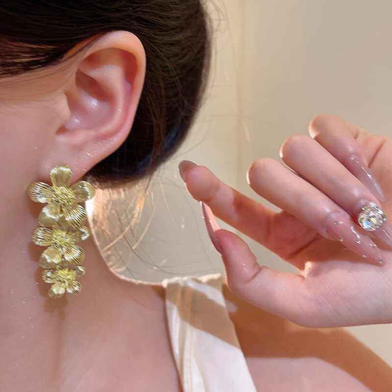 Gold Triple Flower Drop Earrings Worn on Ear
