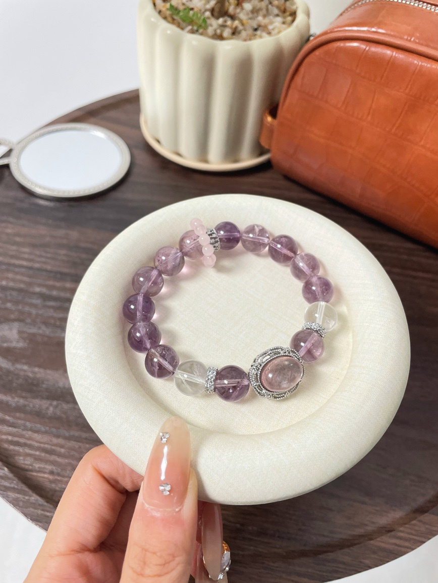 Hand holding Brazilian Amethyst and Kunzite crystal bracelet