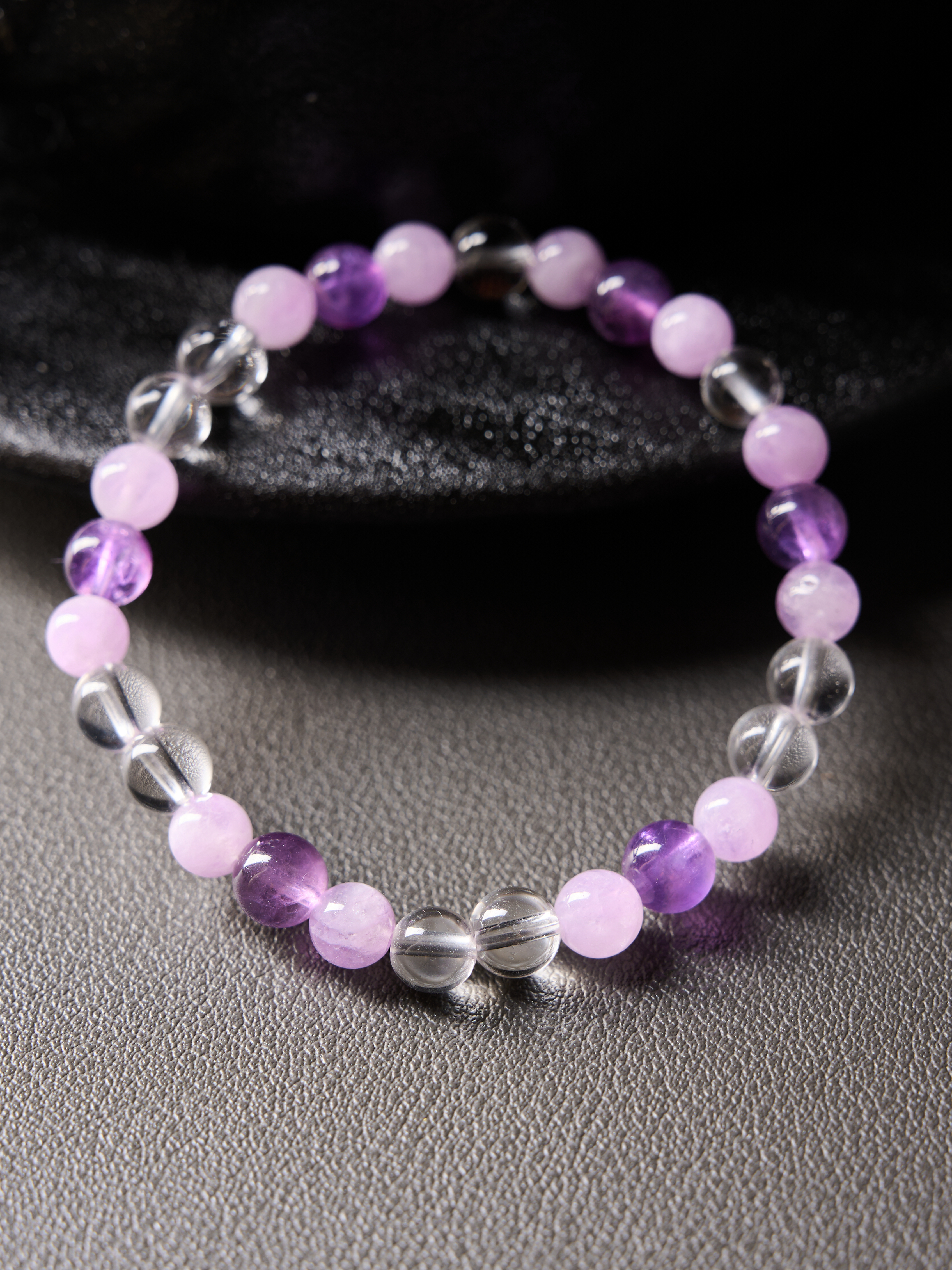 Flat lay circle showing alternating clear quartz, amethyst purple and pale pink kunzite beads