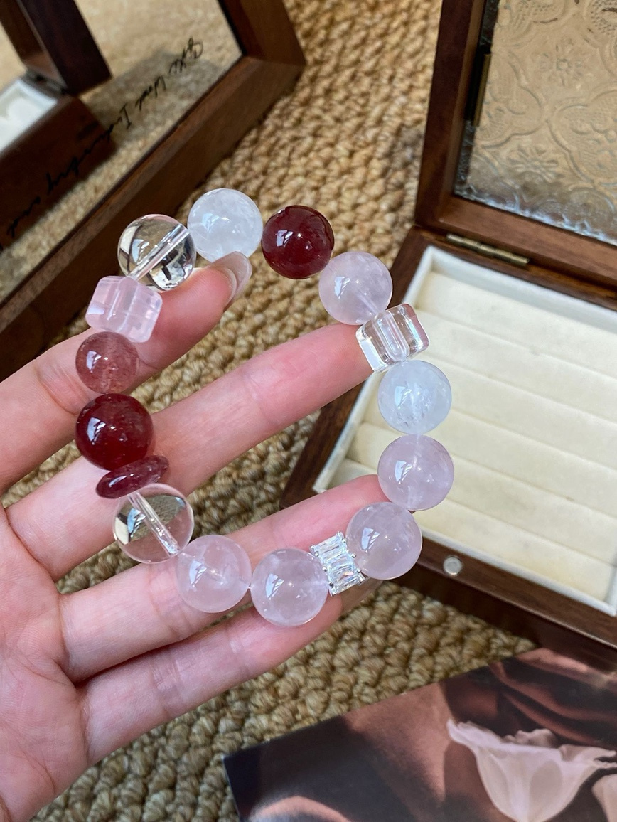 Close-up of pink and clear quartz bracelet on a white plate