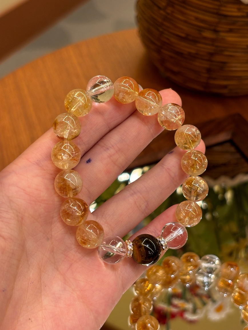 Close-up of golden gemstone bracelet held in hand