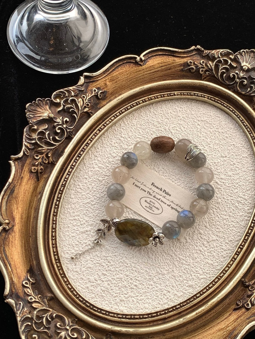 Bracelet displayed in vintage gold frame with gemstone reflections