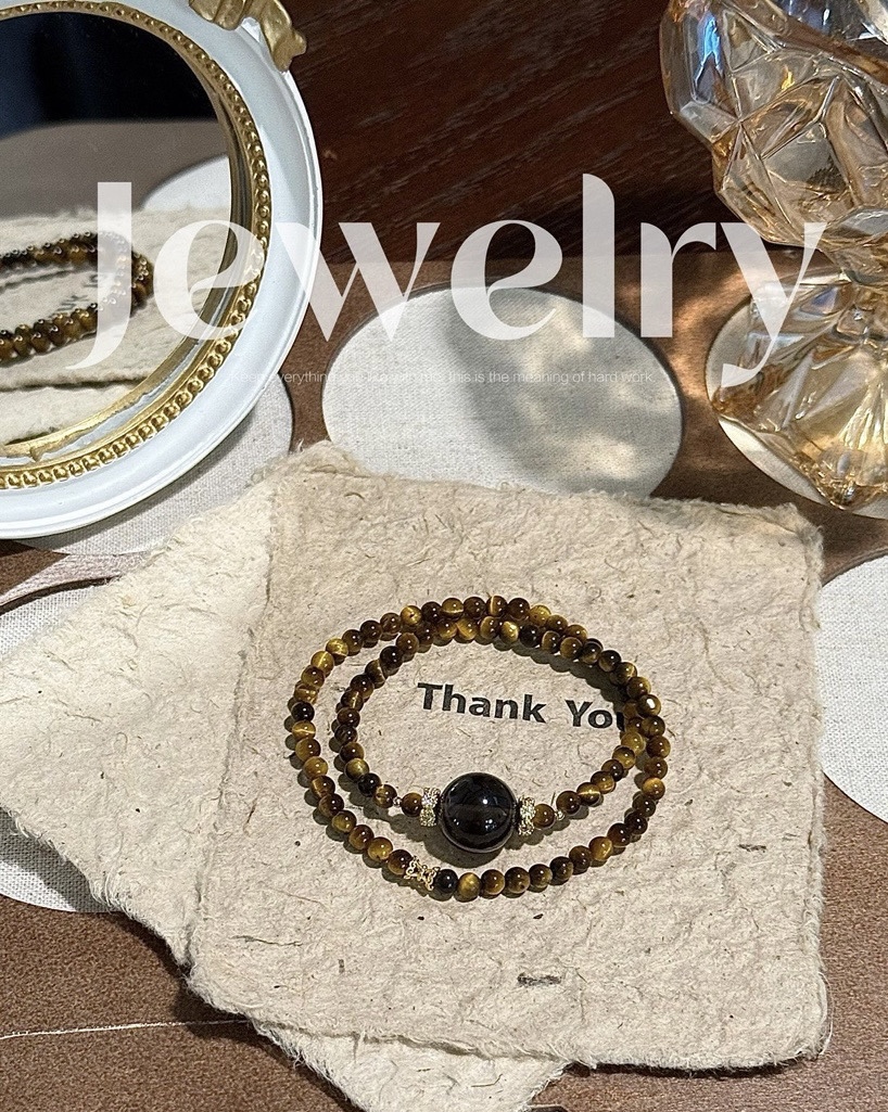 Close-up of Tiger’s Eye and Obsidian beaded bracelet reflecting warm light