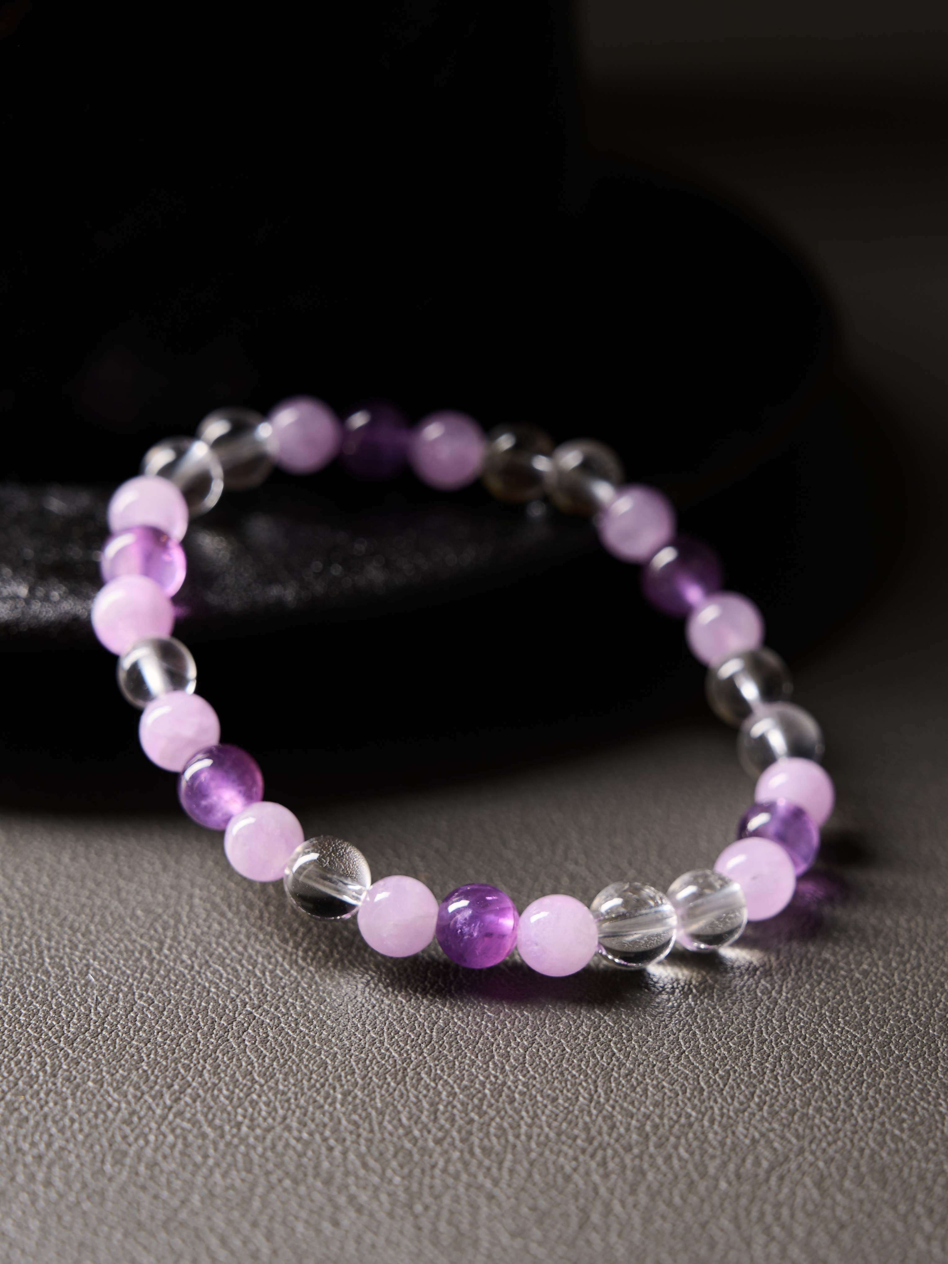 Side view focusing on natural color variation and polish across amethyst and kunzite beads