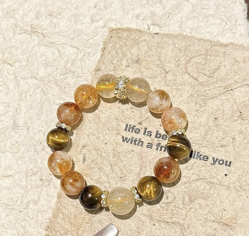 Close-up of gold crystal wealth bracelet under natural sunlight