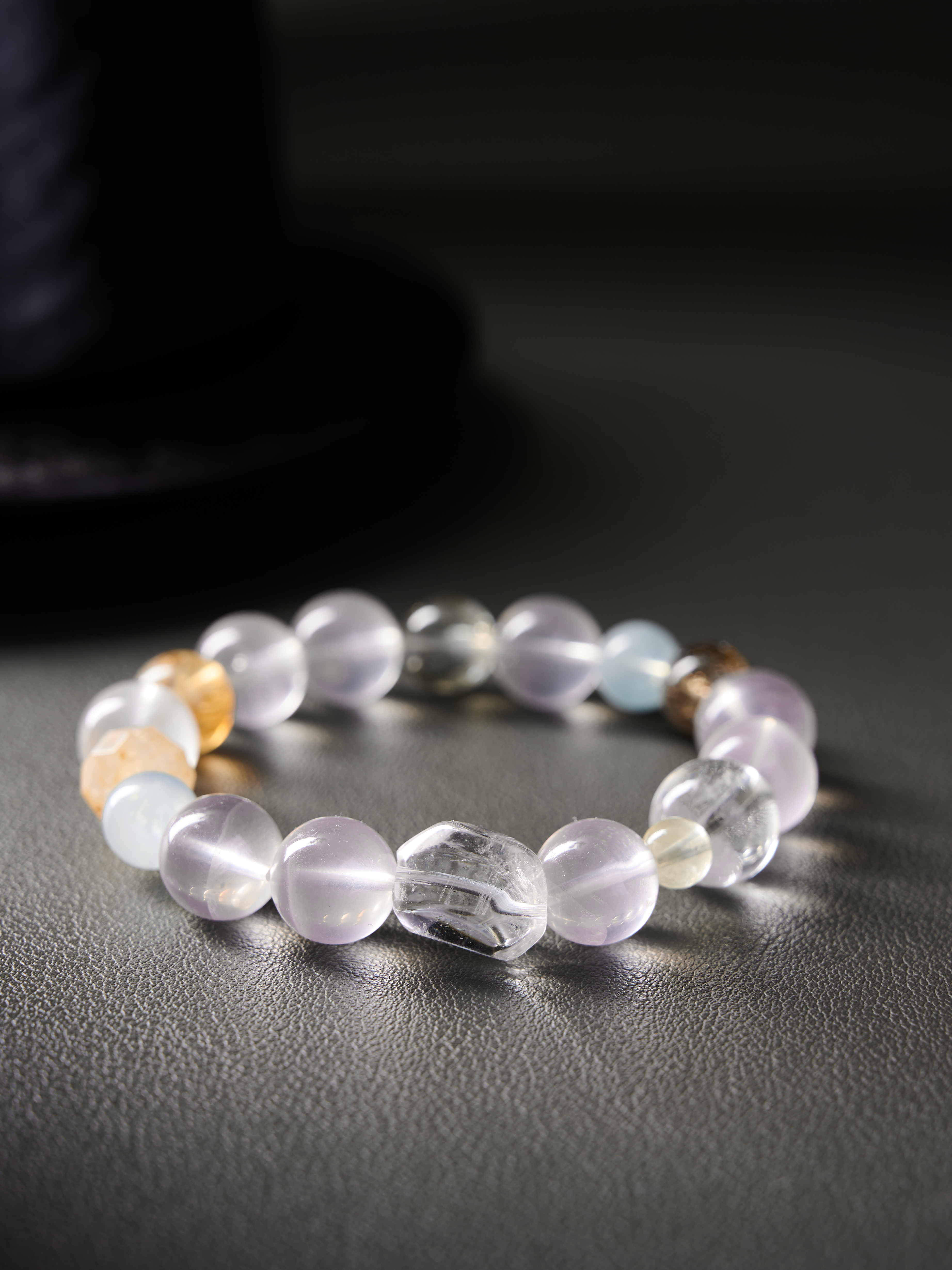 Flat lay at three-quarter angle showing aquamarine glow and clear quartz clarity, hand-strung bracelet