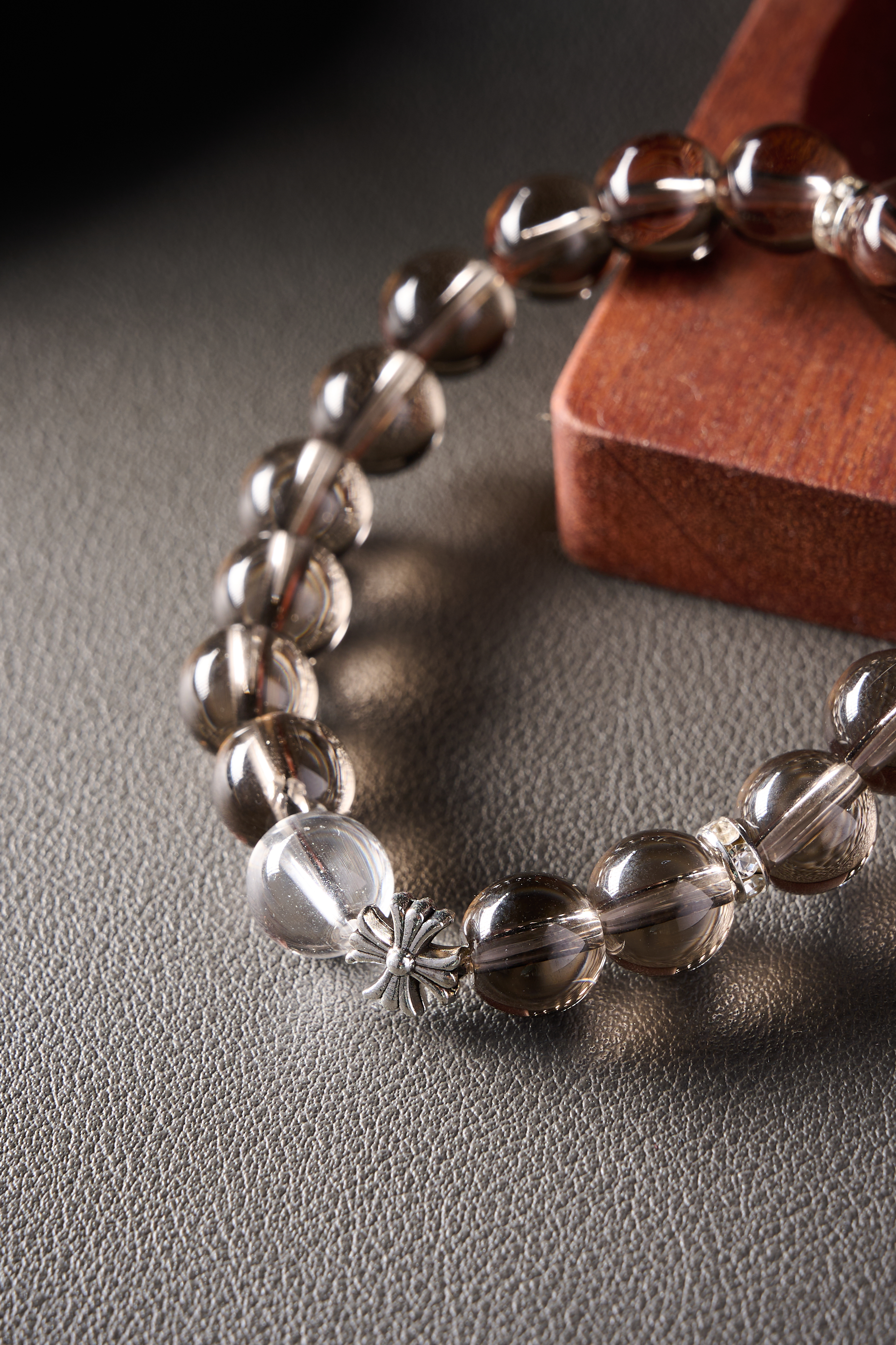 Close-up – smoky quartz bead showing high clarity and internal reflections, glossy surface.