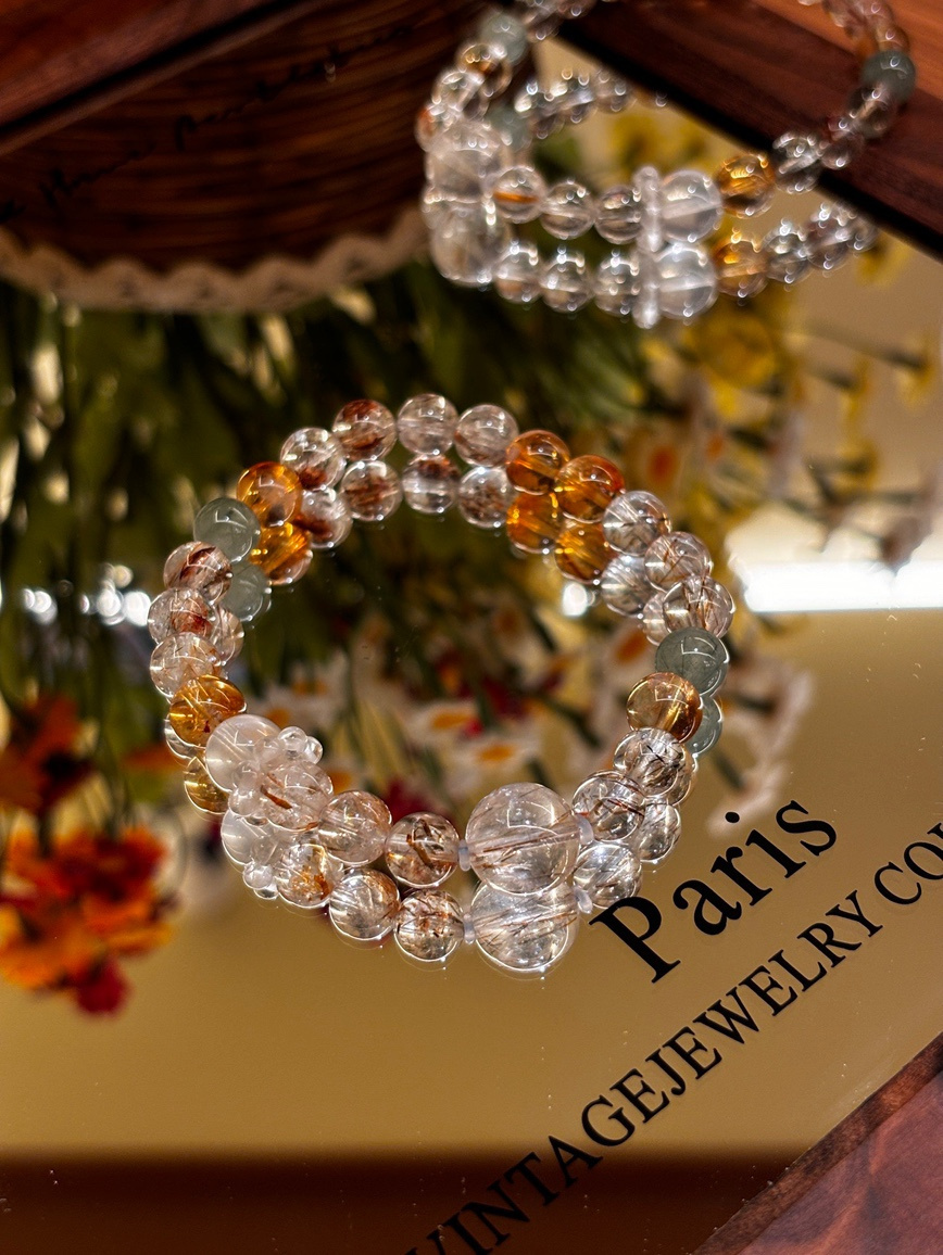 Super Seven crystal bracelet on mirror surface with floral reflection
