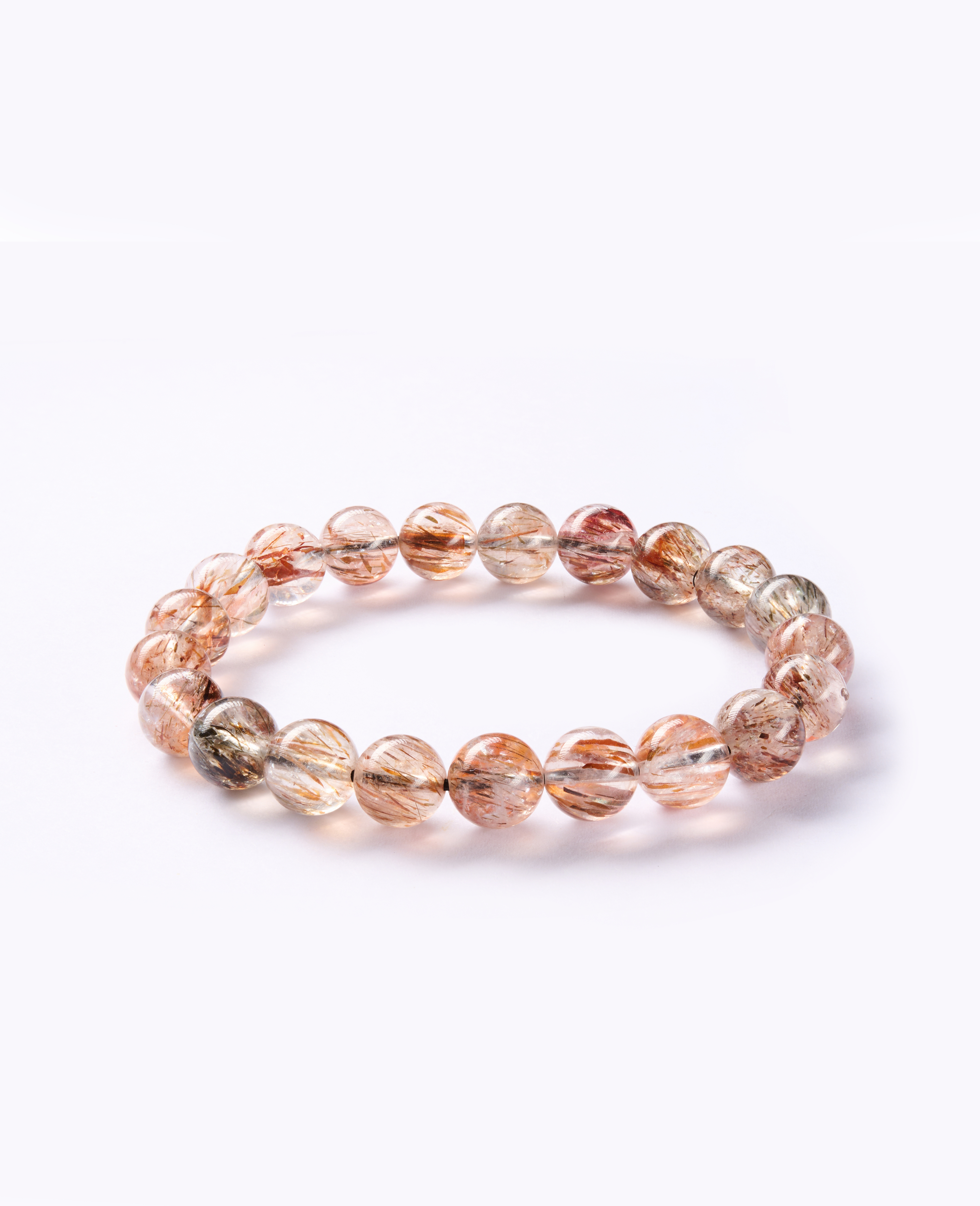 Angled side shot highlighting golden rutile needles and soft reflections on polished beads