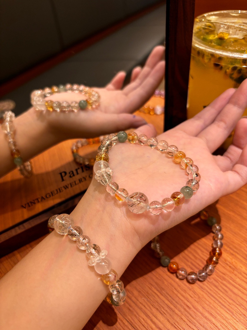 Model wearing Super Seven gemstone bracelet under warm light reflection