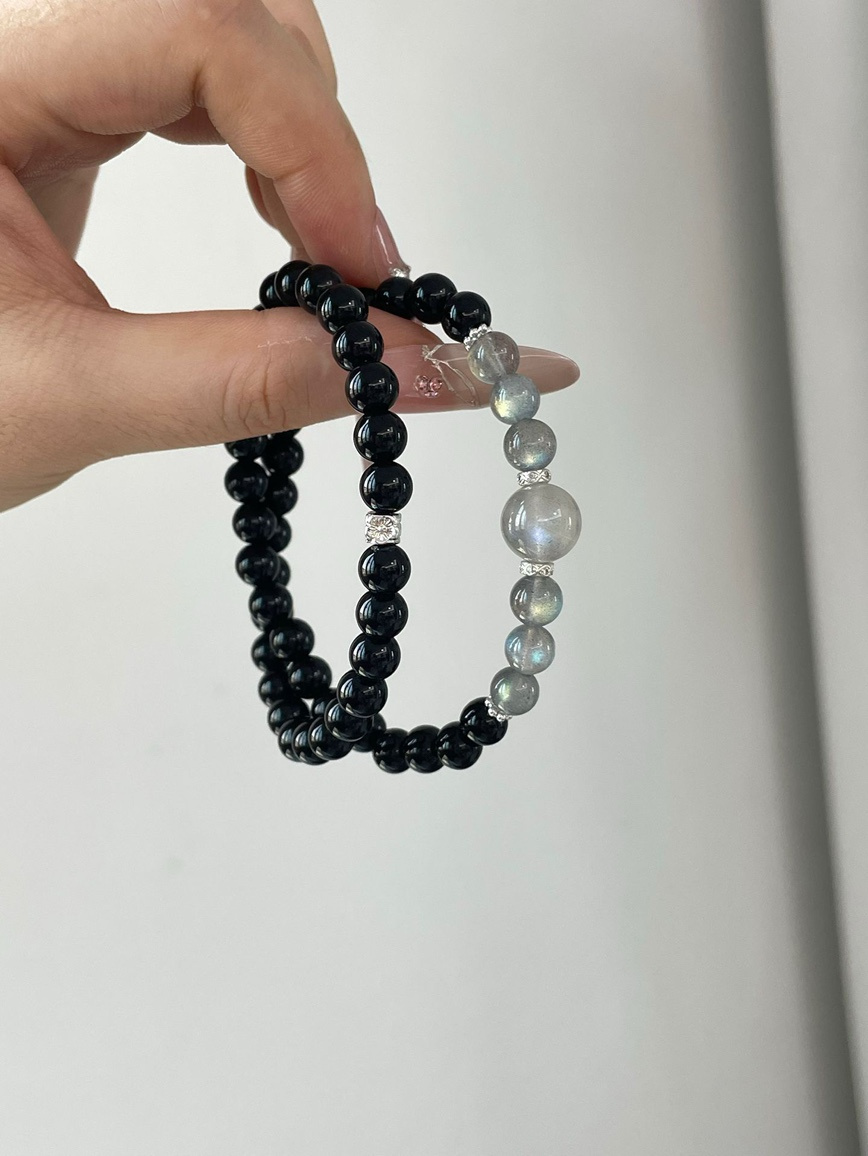 Elegant black and gray gemstone bracelet displayed in hand