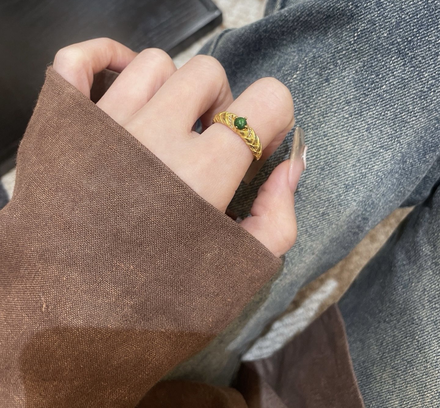Elegant hand wearing jade ring with casual jeans style