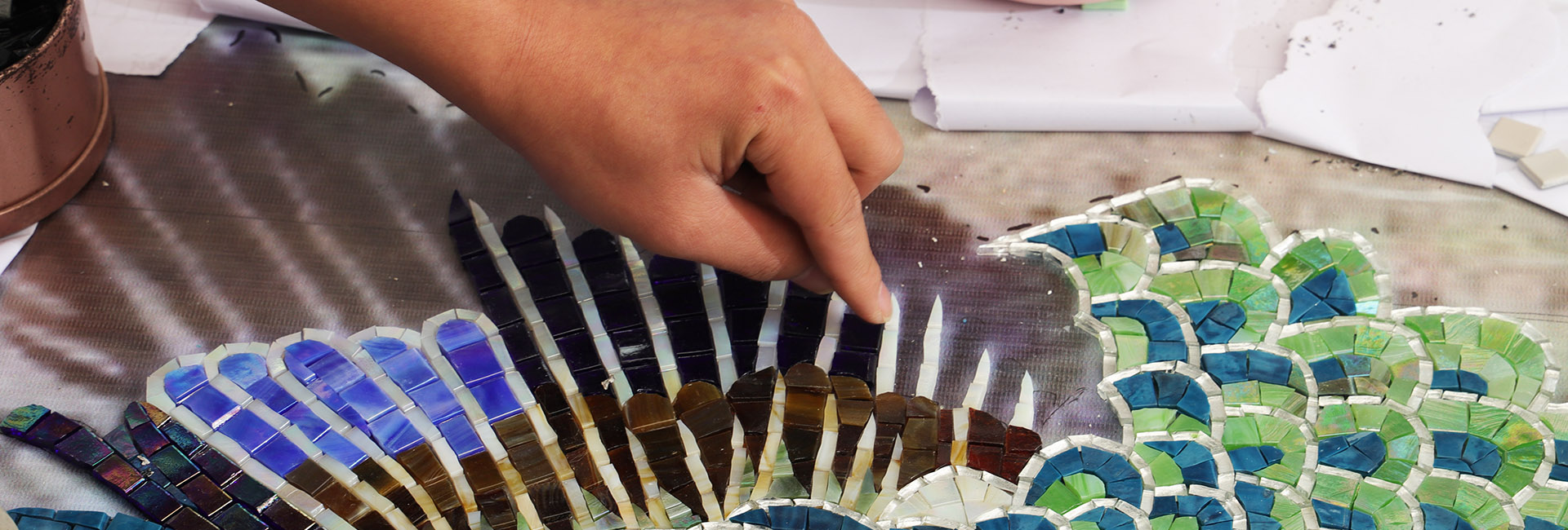 {"default":"Hand arranging colorful glass pieces in a mosaic artwork"}
