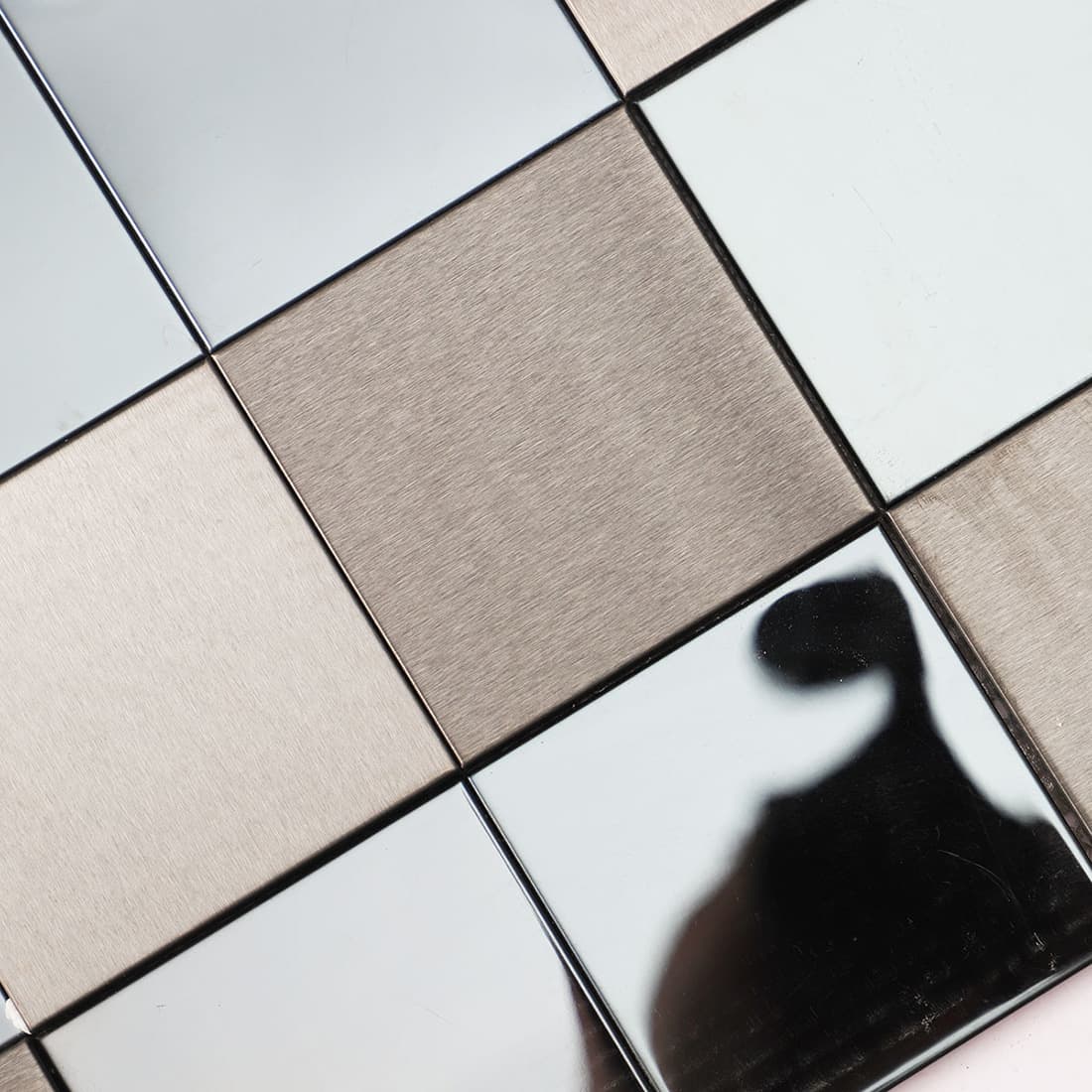 Detail of dark brushed and mirror stainless steel mosaic tile surface