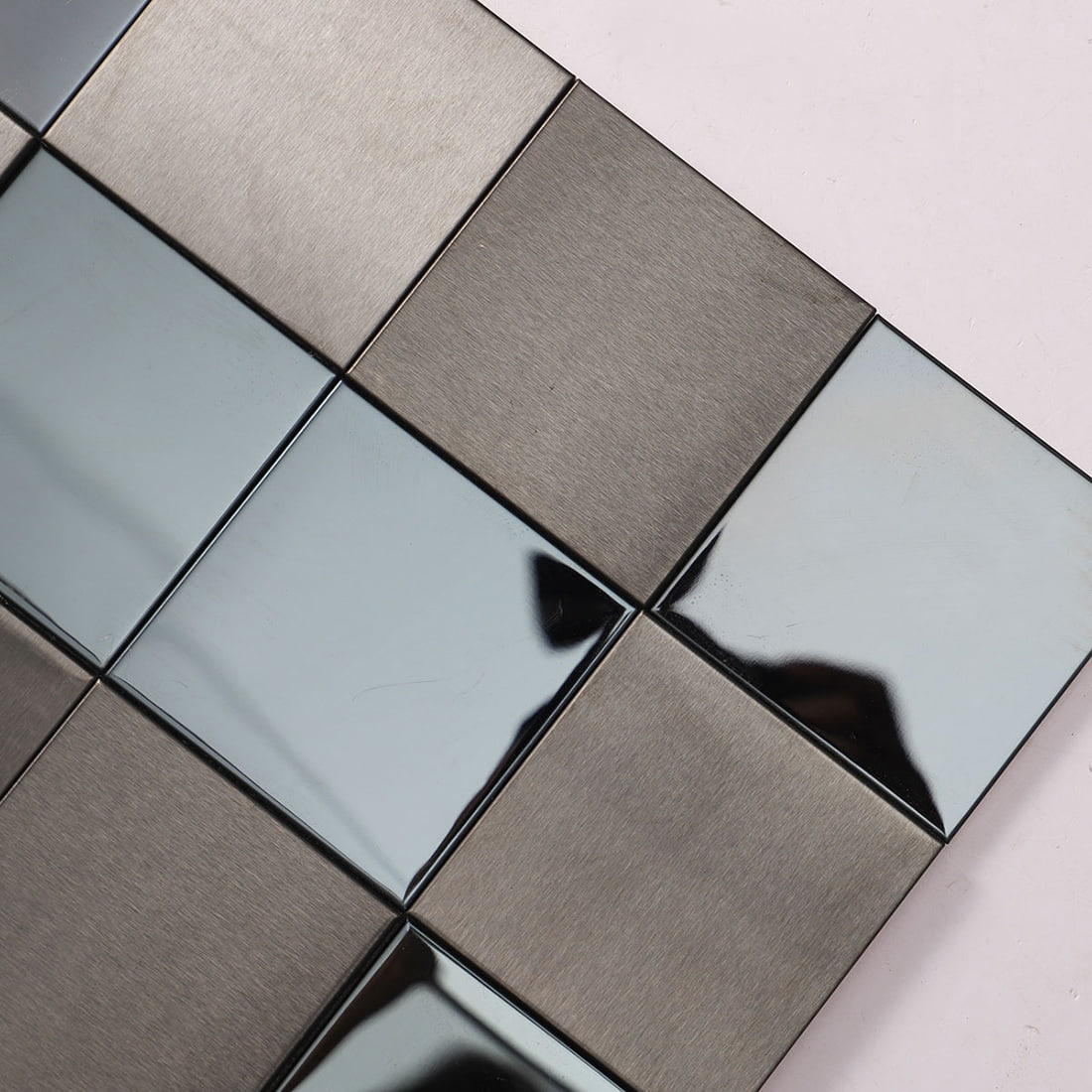 Corner close-up of 3D brushed and mirror stainless steel mosaic tile
