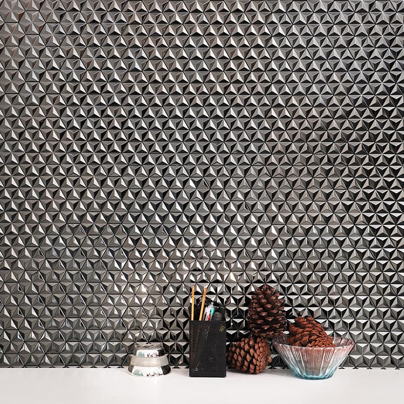 3D metallic silver triangle mosaic tiles in a geometric backsplash pattern.
