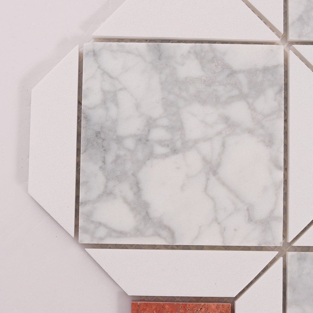 Close-up of white marble mosaic tile with beveled geometric edges