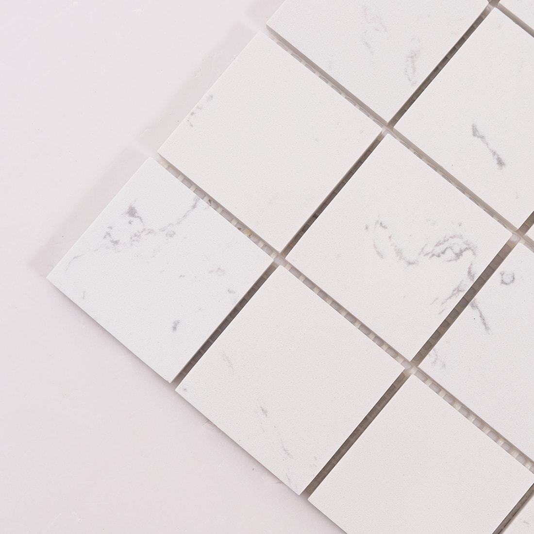 Corner detail of white marble square mosaic tiles with subtle veining