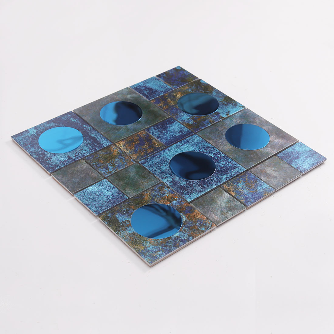 Angled view of dark blue aluminum mosaic tile with round mirror glass inserts