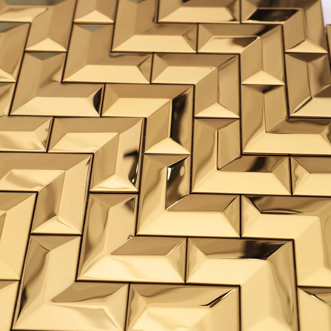 A close-up view capturing the reflective mirror finish of gold chevron tiles.