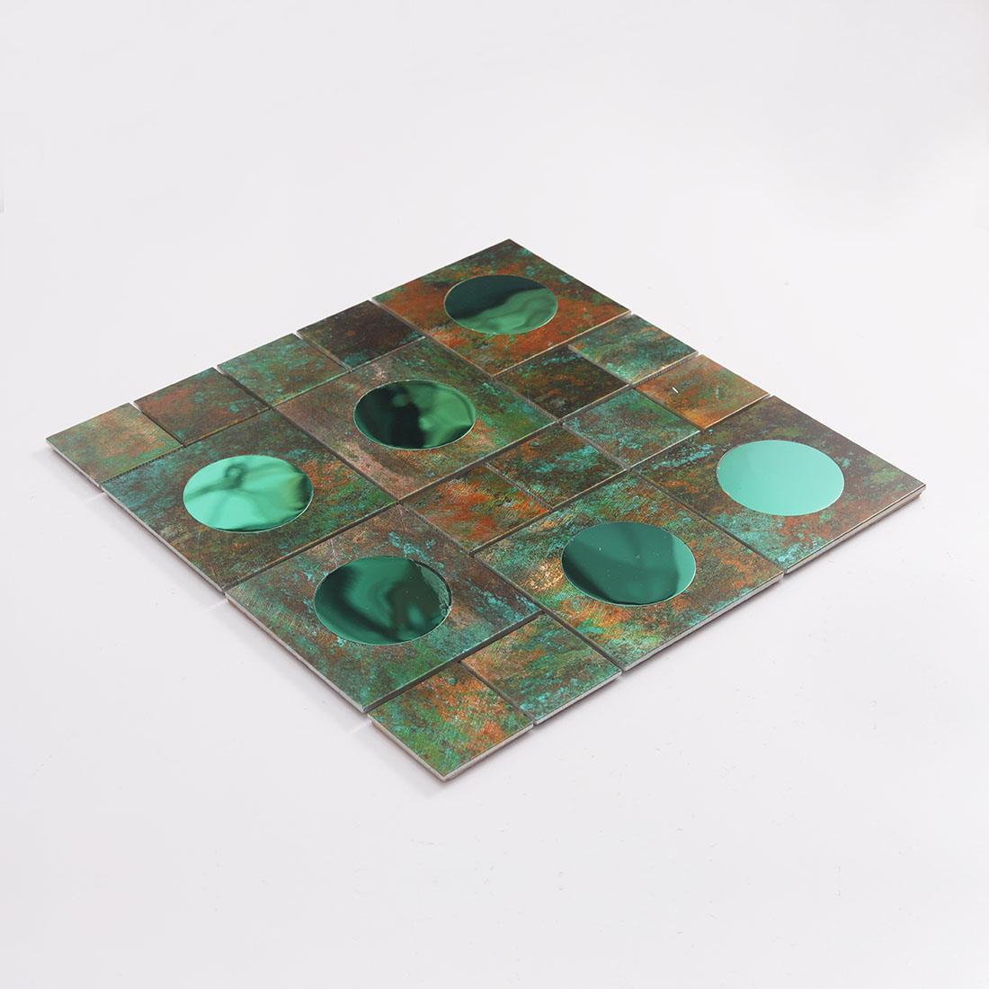 Angled view of verdigris green aluminum mosaic with round mirror glass