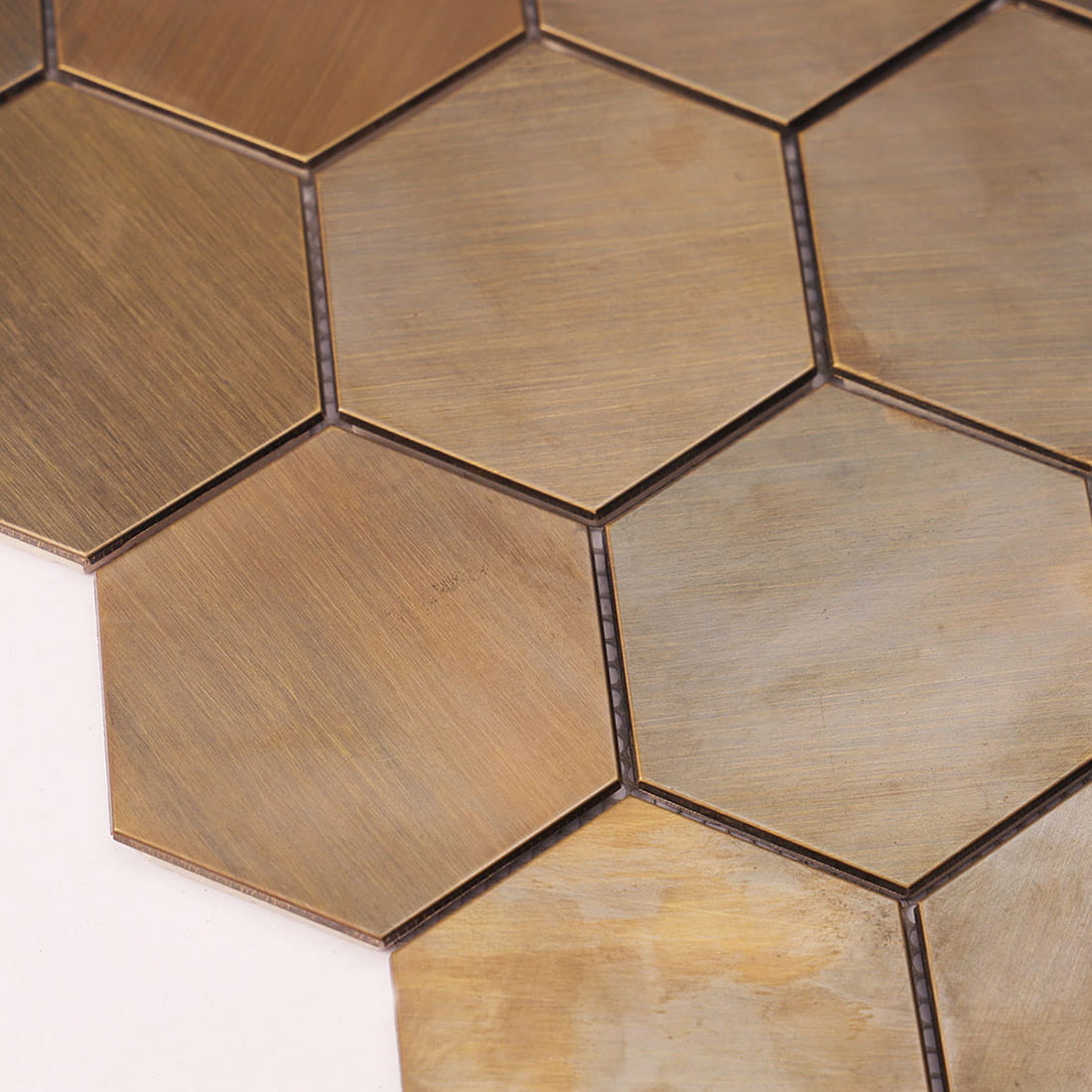 An angled close-up view of brushed brass hexagon mosaic wall tiles.