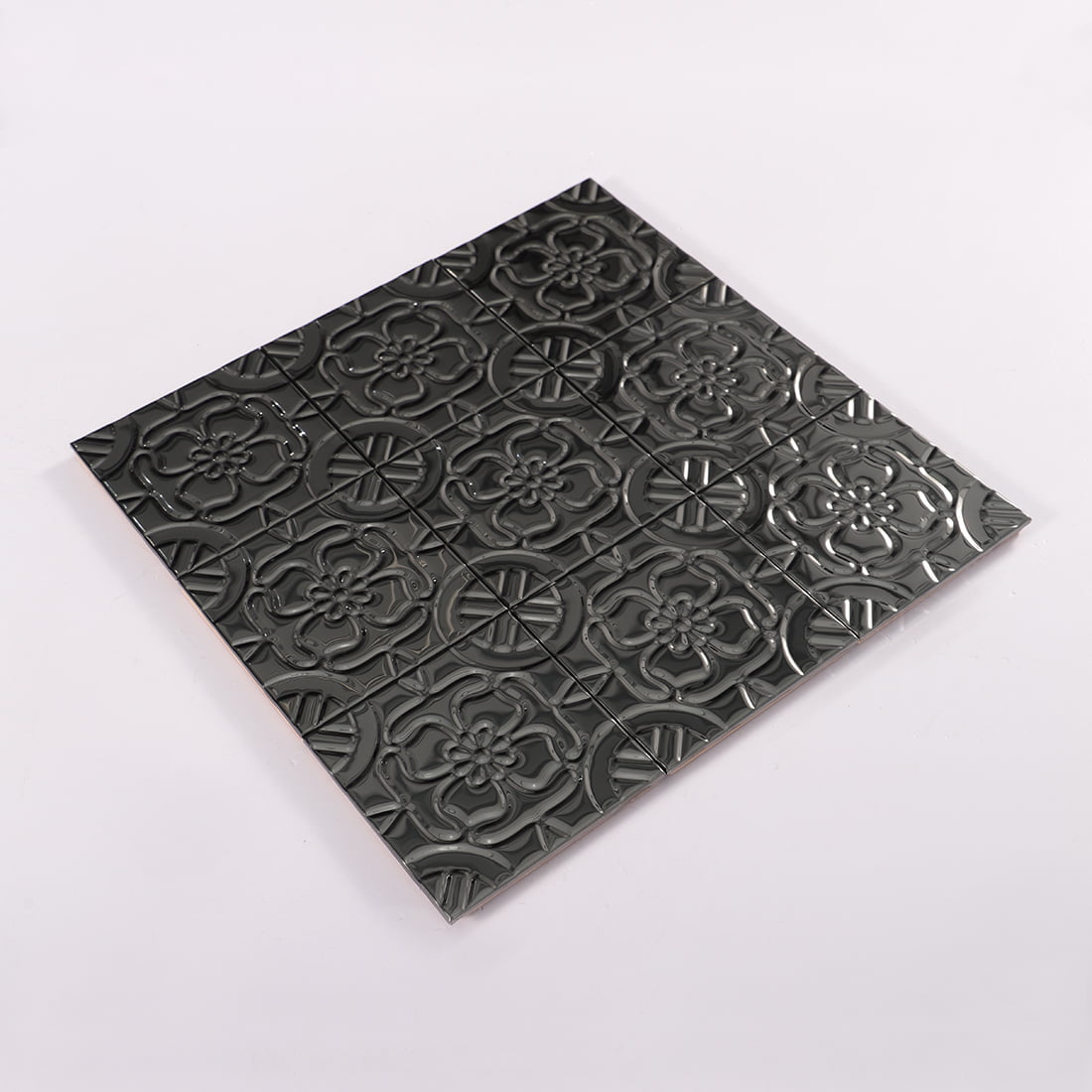 Angled perspective view of full black stainless steel floral embossed tile mosaic sheet