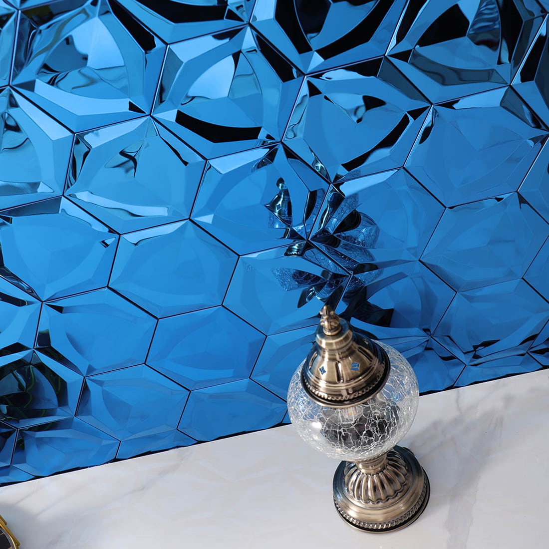 Angled shot showing light reflections on a blue 3D hexagon mosaic wall.