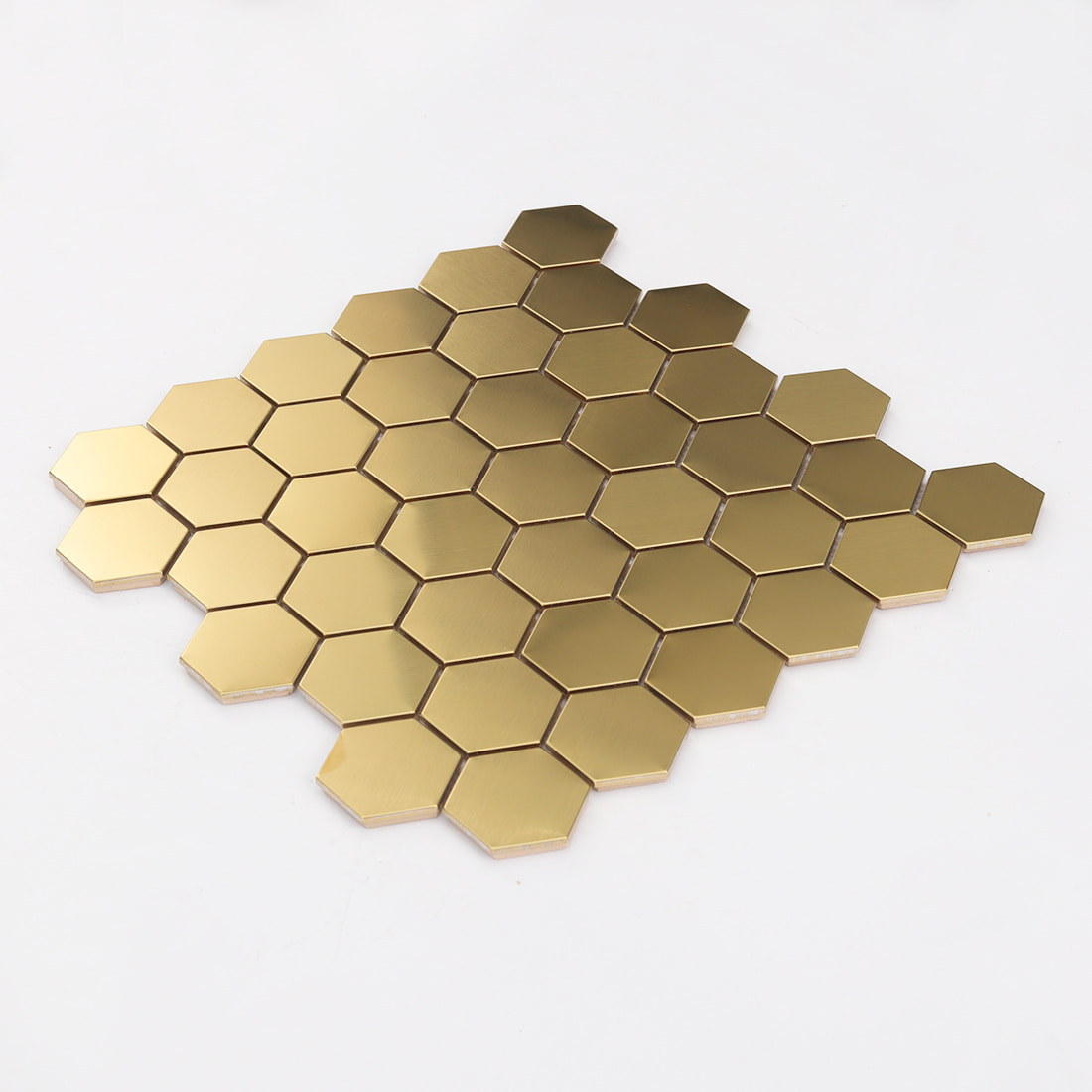 Angled view of a large gold hexagon stainless steel mosaic tile sheet.