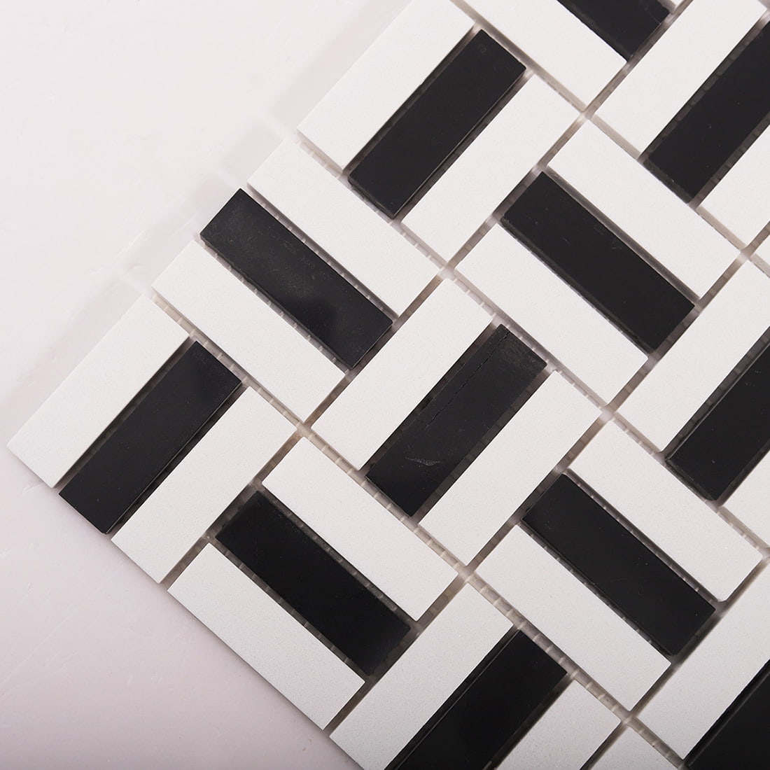 Diagonal close-up of black and white basket weave mosaic tiles