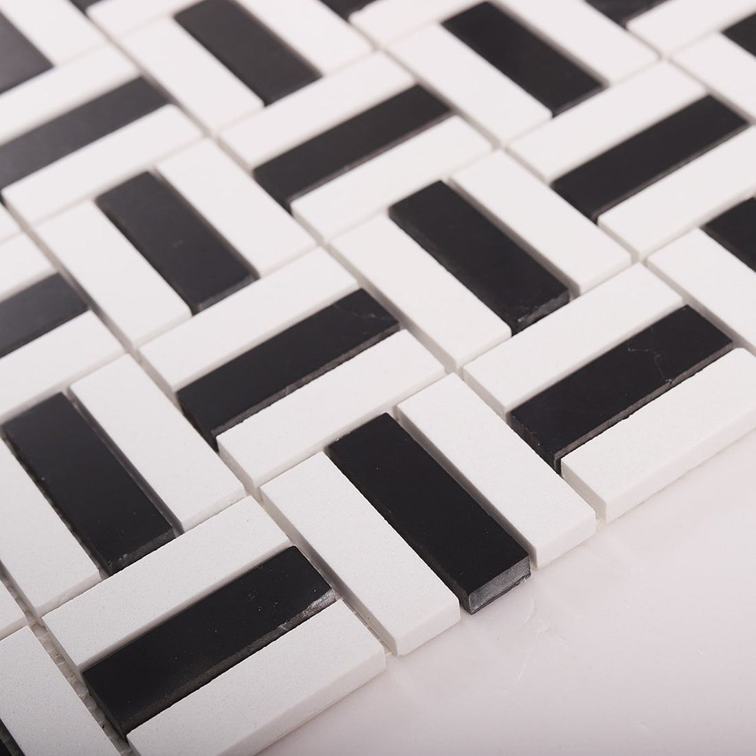 Close-up of tile sheet edge with black and white basket weave mosaic