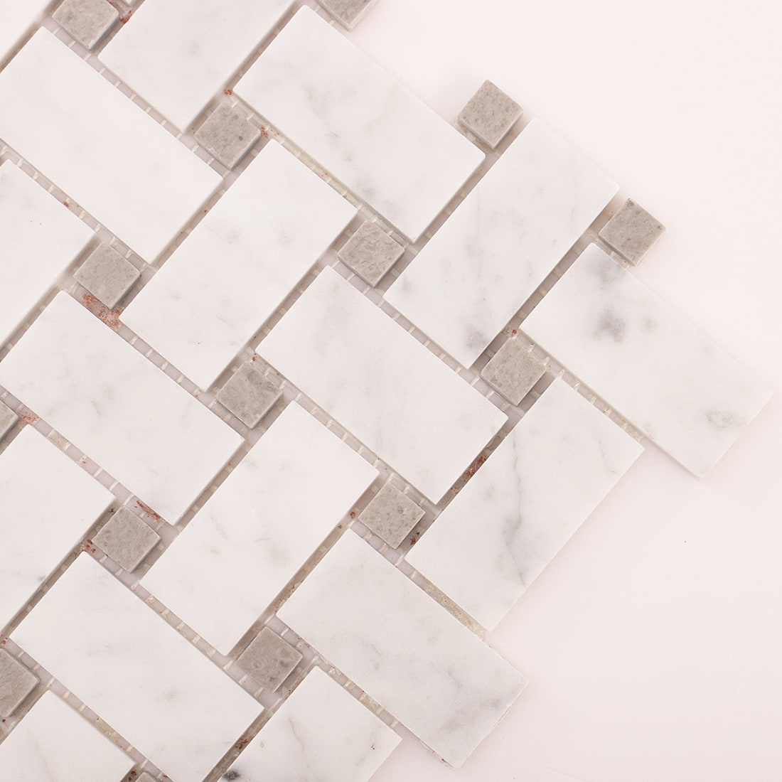Diagonal close-up of white marble basketweave mosaic with gray square accents