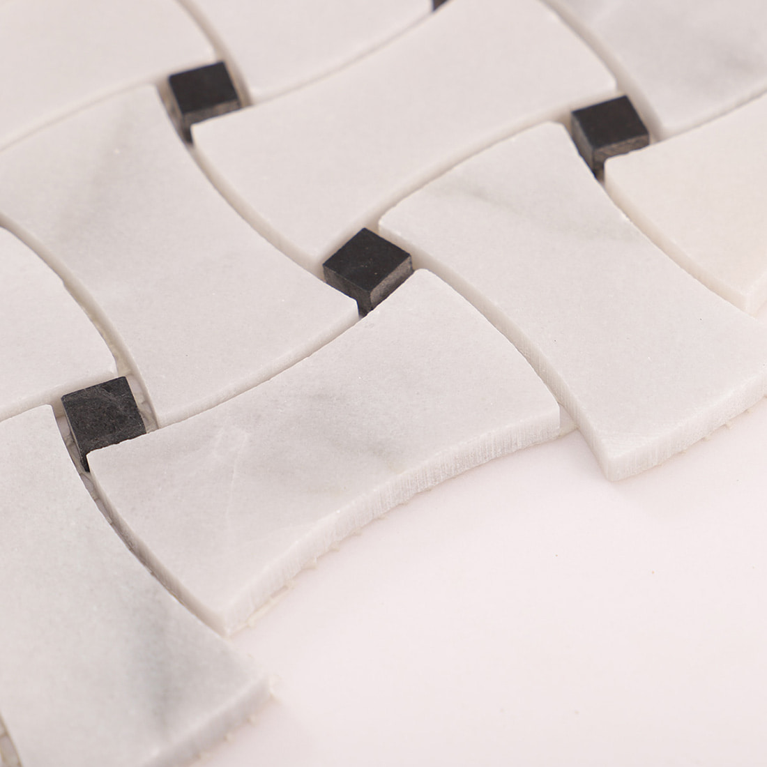 Close-up showing the edge thickness of a basketweave marble mosaic tile piece.