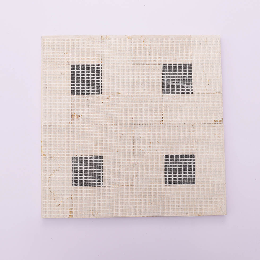 Back view of beige black marble mosaic tile sheet with mesh backing