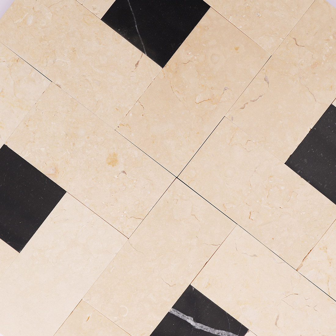 Close-up of beige black marble mosaic tile with contrasting square accents